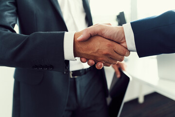 Business handshake closeup. Two businessman shaking hands after successful recruitment