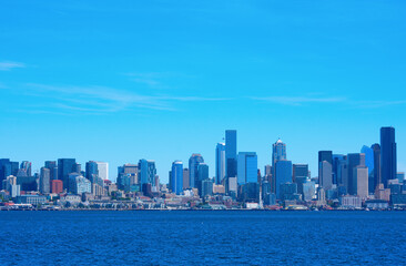 Fototapeta na wymiar Colorful Seattle, Washington, also known as the Emerald City, skyline on a rare sunny summer morning with densely packed buildings along the Puget Sound waterfront.