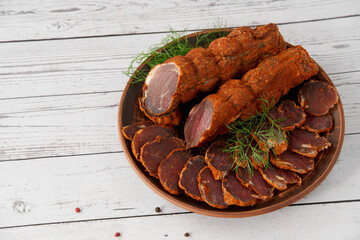 Homemade jerked dried meat or biltong with spices on a wooden background. Beer snack concept. Selective focus, copyspace.