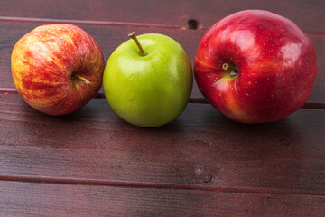 Close up view of ripe colorful apples isolated on wooden background. Organic vegetables concept.
