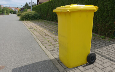Yellow recycling can out on the street for pick up in a German suburb.