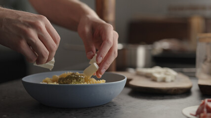 add mozzarella to fusilli pasta in blue bowl