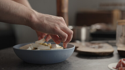 add mozzarella to fusilli pasta in blue bowl