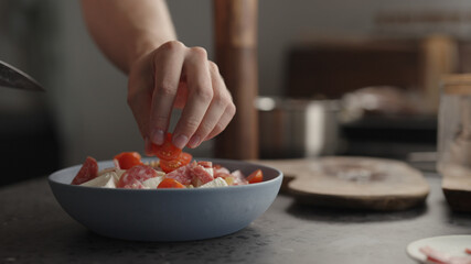 add cherry tomatoes to fusilli pasta in blue bowl