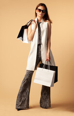 fashion shopper with shopping bags isolated on brown background