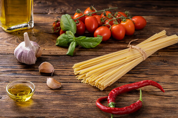 wooden board with raw ingredients to season pasta in Italian way