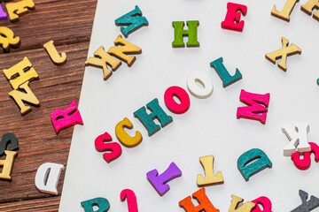 School creative flatley. On a wooden table lie multicolored letters with the inscription school.