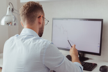 Businessman looking on falling stock chart on screen. Analyze correction