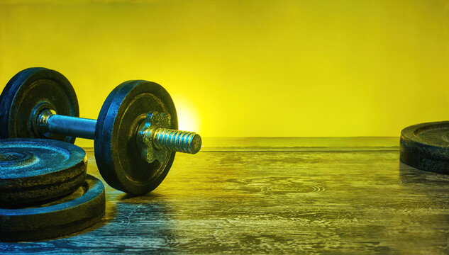 Heavy dumbbells in a gym concept. Vibrant, fitness background, with copy space for products or text