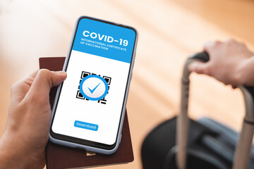 Digital certificate of covid vaccination app - Traveler holding health immunity passport on mobile phone at airpot