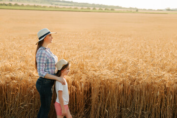 side view, portrait family of farmers mother with daughter in hats in wheat golden field. Agro walk...