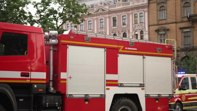 Fire Truck Pulls Up To The Scene Of An Accident At Day. Firetruck Driving On A Road