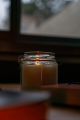 candles and books in a dark warm setting with a picture of an anchor in the background
