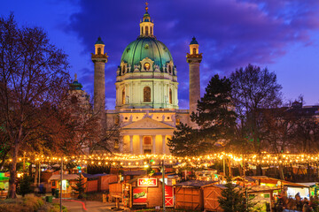 Fototapeta na wymiar Festive cityscape - view of the Christmas Market on Karlsplatz (Charles' Square) and the Karlskirche (St. Charles Church) in the city of Vienna, Austria, 3 December, 2019