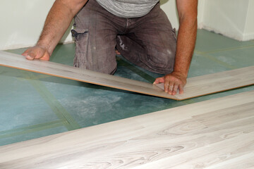 a man is installing a laminate on the floor close-up