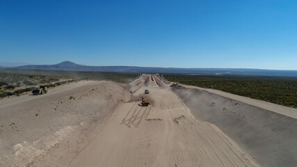 Excavator loading truck of stones, in road construction.