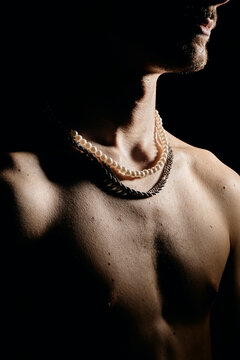 jeune homme homosexuel torse nu portant des bijoux