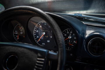 View of the interior of an old classic car with clocks in background.