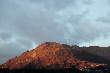 Clouds over the mountains at sunset in Alpago