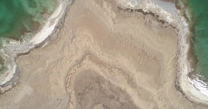 Aerial view of the texturized expanding shoreline in the Dead sea as the water level decreases, Negev, Israel.