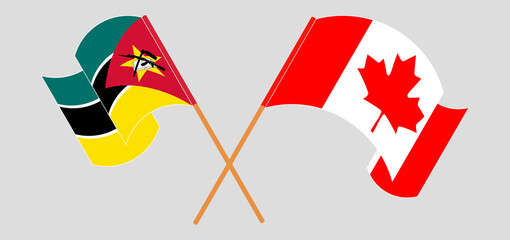 Crossed and waving flags of Mozambique and Canada