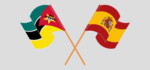Crossed and waving flags of Mozambique and Spain