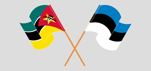 Crossed and waving flags of Mozambique and Estonia