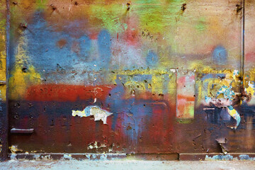 Colorful dirty wall with vivid blue, red, yellow, green colors and flaking plaster texture for backgrounds