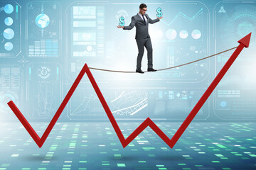 Businessman balancing on tightrope on line chart