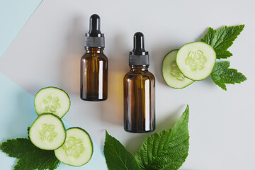 mock up blank amber glass bottle with pipettes and cucumber slices, dark brown dropper bottle with cosmetic product