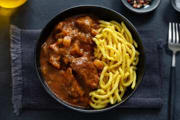 Meat ragout stew with noodles in bowl