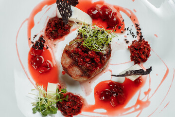 Appetizing beef in sweet sauce close up. Chopped beef meat in cherry sauce with vegetables on plate. Delicious european cuisine