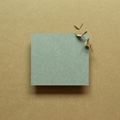 Green blank memo paper with eucalyptus leaf on brown background. top view, copy space