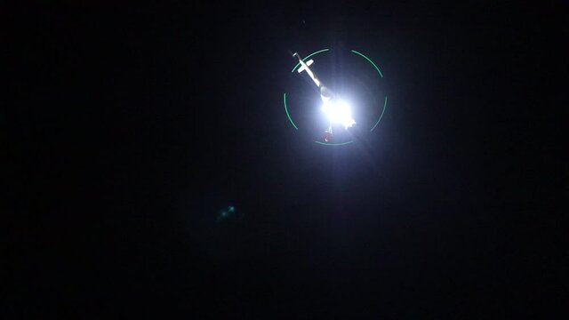 night vision firefighting helicopter takes water from the sea.