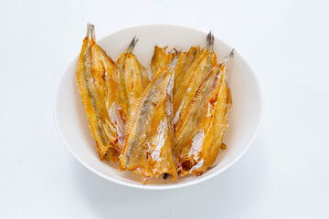 Sun dried black kingfish in white bowl on white background.