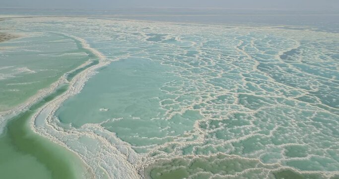 Aerial view of beautiful rock formation and sinkholes along Dead Sea shoreline, Jordan Rift Valley, Negev, Israel.