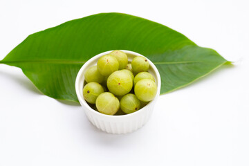 Fresh emblica in white ceramic cup on white background.