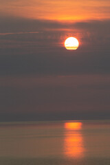 Beautiful Sunset Going Down On A Lake With The Sun Peeking Behind The Clouds 