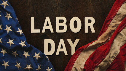 Fototapeta na wymiar Vintage US American flag crumpled on worn wooden background with Labor Day text, celebrating American workers.