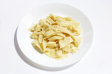 Preserved bamboo shoot slices in white plate on white background.