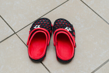 red and black sandals. Children's rubber shoes for the pool.