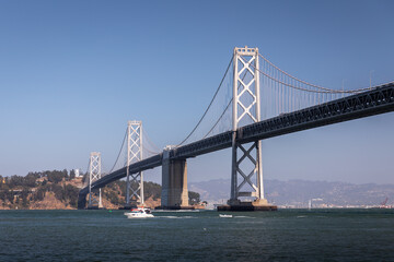 Fototapeta na wymiar Landscape of San Francisco - Oakland bay bridge with running boat.