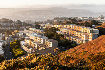 Old buildings on hill slope of Twin Peaks at sunrise.