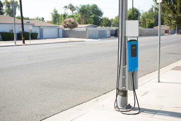 A view of an electric vehicle charging station, installed on the side of a local street, seen in...