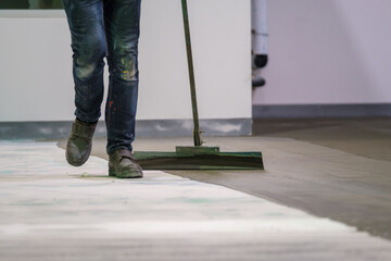 Construction worker using trowel spreading moisture blocking epoxy primer for Self-leveling method...
