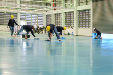 Construction workers are using trowel spreading epoxy putty for Self-leveling method of epoxy floor...