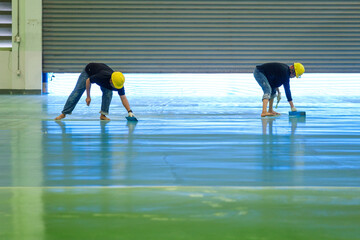 Construction workers are using trowel spreading epoxy putty for Self-leveling method of epoxy floor...