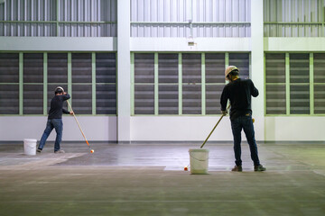 Construction worker using rollor spreading epoxy primer for Self-leveling method of epoxy floor...