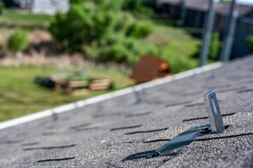 Residential asphalt shingle roof with metal anchors installed for the installation of a solar panel rail and racking system