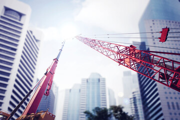 Mobile crane and tower crane with modern cityscape